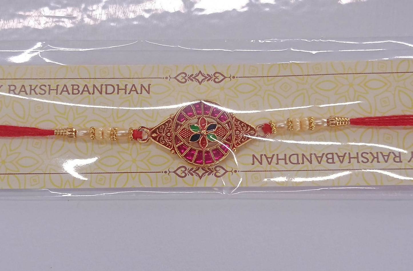 Traditional Rakhi With Round Floral Meenakari Dial And Pink Stone Embellishments