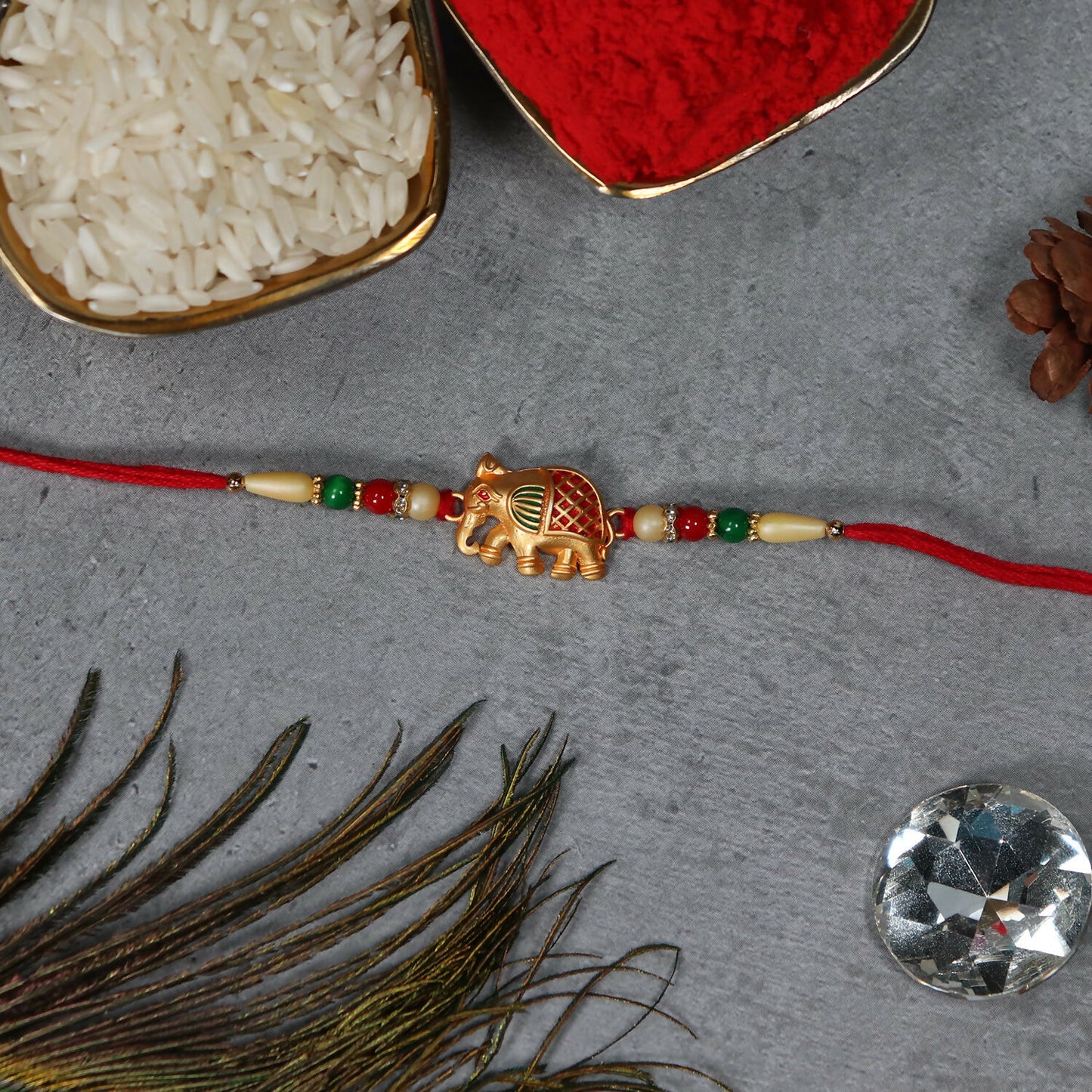 Golden Elephant Rakhi With Red Green Moti